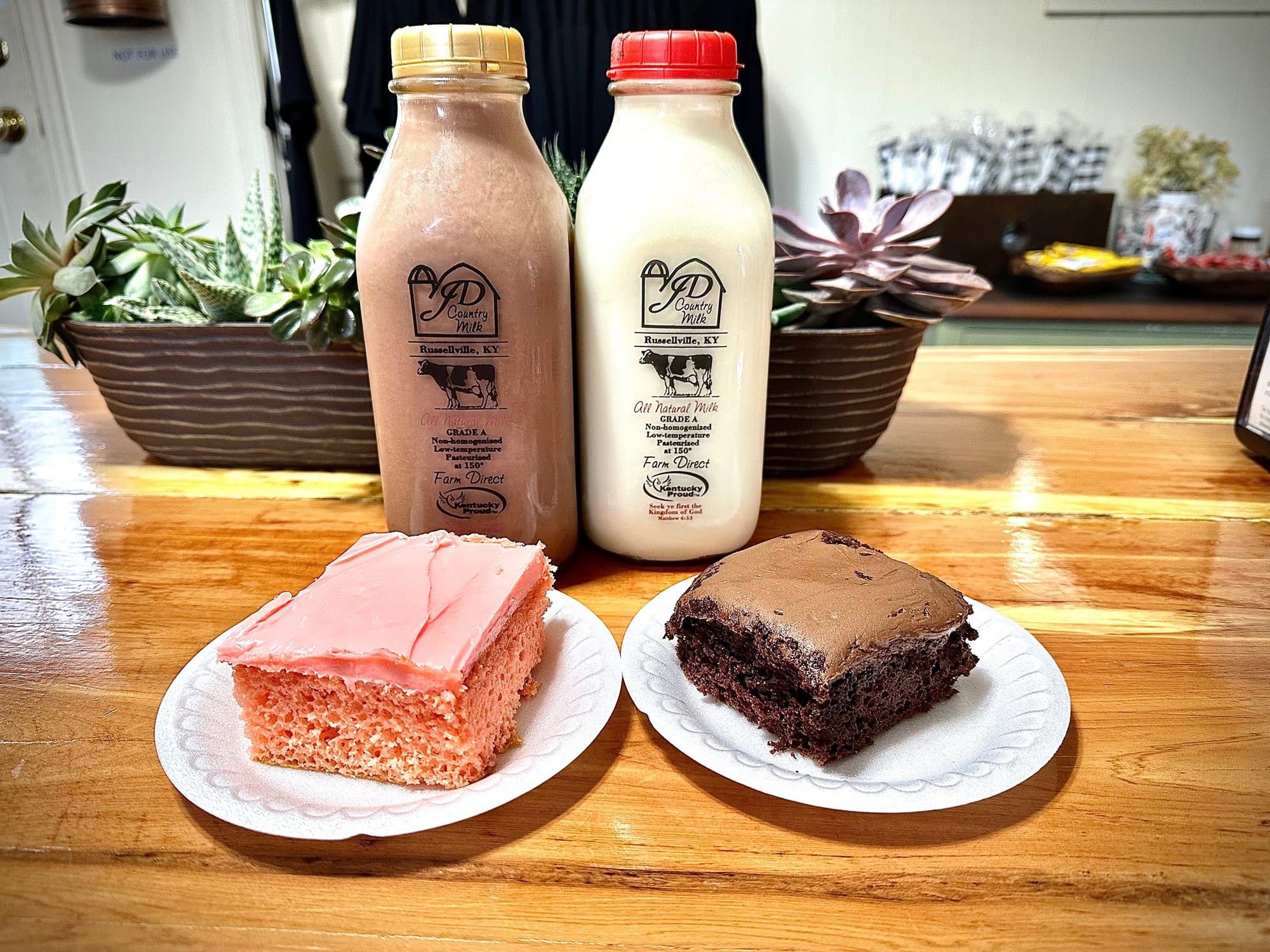 Strawberry and chocolate cake squares with bottled milk